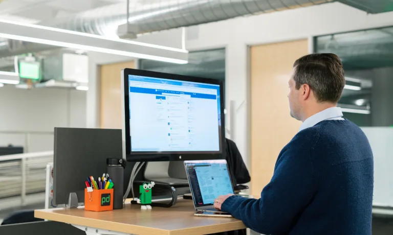 A Man in Blue Long Sleeves Using a Laptop